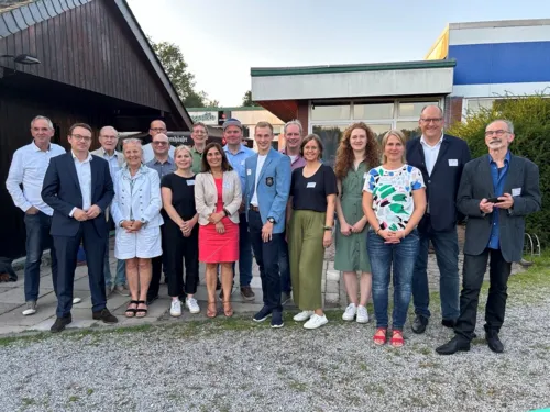 Damen und Herren stehen nebeneinander zu einem Foto