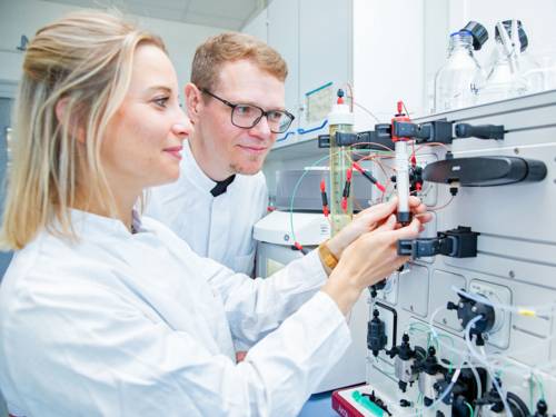 Eine Frau und ein Mann in weißen Kitteln in einem Labor