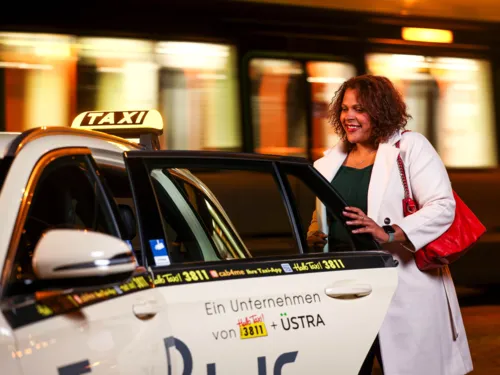 Frau, die in ein Taxi steigt.