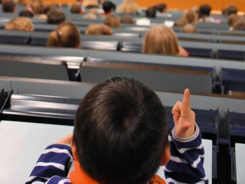 Kind in Hörsaal von hinten aufgenommen