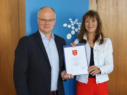 Ein Mann und eine Frau halten eine Urkunde