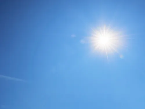 Eine gleißend hell strahlende Sonne auf blauem Himmel