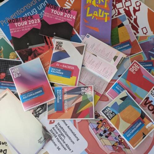 Viele Flyer auf einen Tisch verteilt.