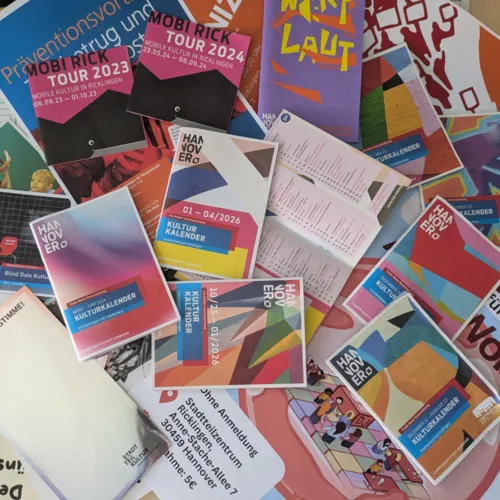 Viele Flyer auf einen Tisch verteilt.