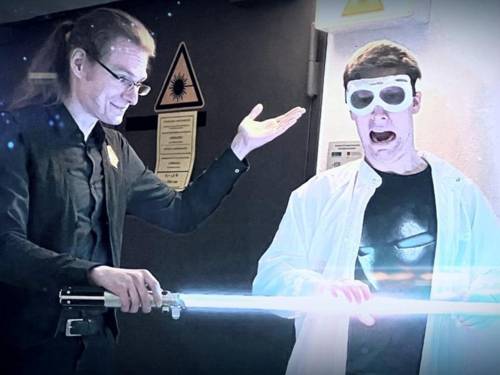 Ein Wissenschaftler zeigt einem anderen ein Laserschwert.