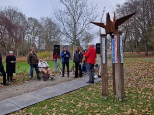 Menschen stehen neben einem Holzpfahl.
