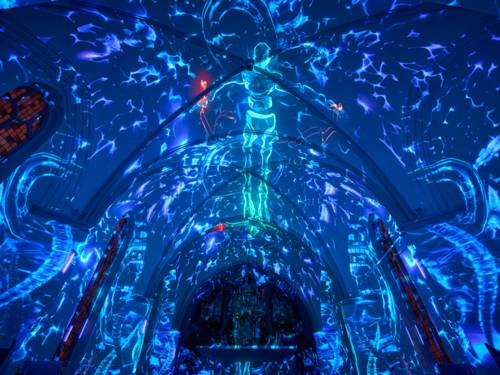 Ein Kirchengewölbe wird mit Wassermotiven einer Lichtprojektion beleuchtet