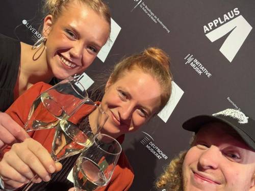 Zwei Frauen und ein Mann mit Sektgläsern