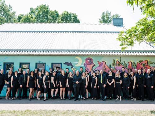 Zahlreiche Menschen in schwarzer Kleidung stehen vor einem Gebäude.