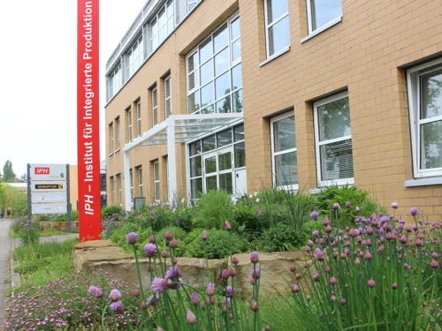 Eingang eines Gebäudes mit Pylon mit der Aufschrift "IPH – Institut für Integrierte Produktion"