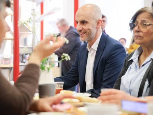Vier Menschen sitzen an einem Tisch und sprechen miteinander.