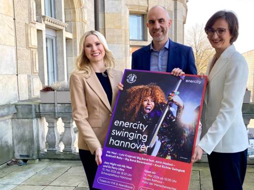 Zwei Frauen und ein Mann halten ein Plakat.