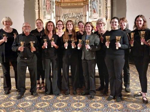 Menschen mit Handglocken in den Händen