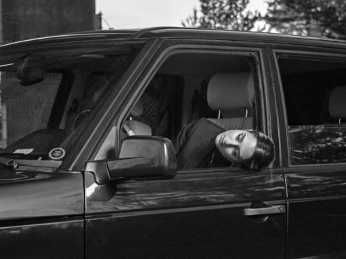 Die Sängerin schaut auf dem Fahrersitz sitzend aus einem Auto heraus.