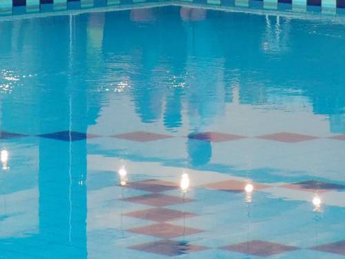 Blick auf ein Schwimmbecken mit Lichtreflexionen.