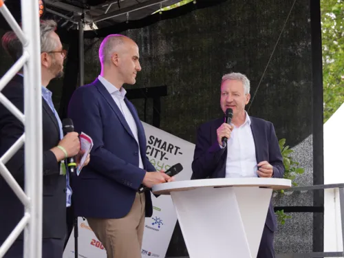 Drei Personen auf einer Bühne.