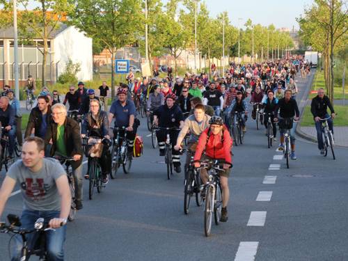 Viele Radfahrer im Tross auf einer Straße.