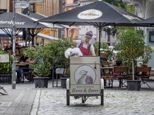 Ein Mann sitzt auf einem dreirädrigen mobilen Eisverkaufsfahrzeug.