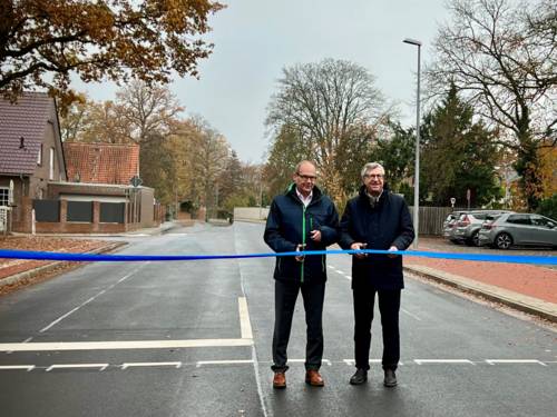 Zwei Personen durchschneiden auf einer Straße ein Band