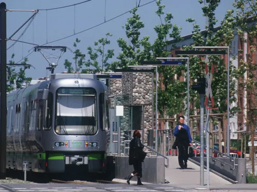 Straßenbahn an einem Hochbahnsteig.
