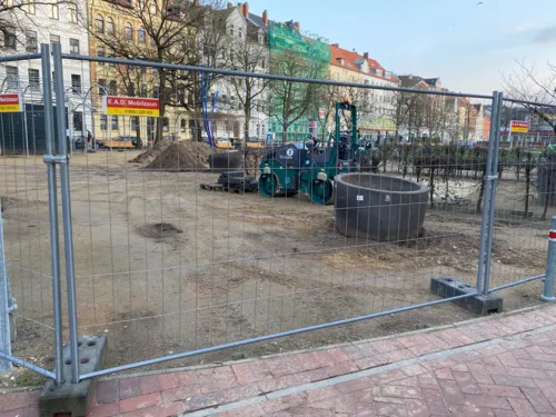 Eine Baustelle. Davor ein Zaun.