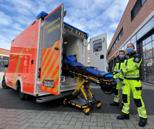 Notfallsanitäter*innen vor Rettungswagen