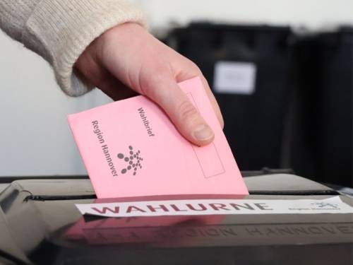 Wahlbrief wird in Urne gesteckt