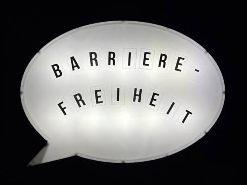 Auf einer Leuchtbox steht das Wort Barrierefreiheit.