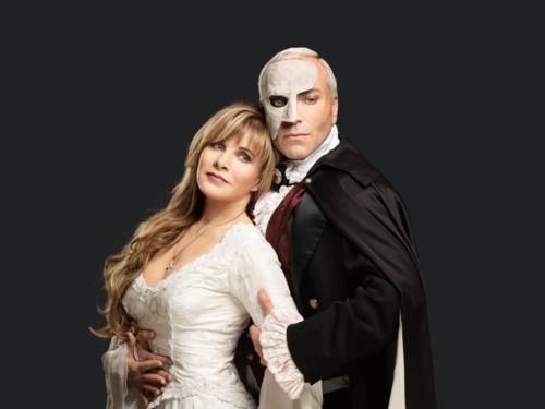 Frau mit blonden Harren und einem Kleid, wird von einem Mann mit Maske gehalten.