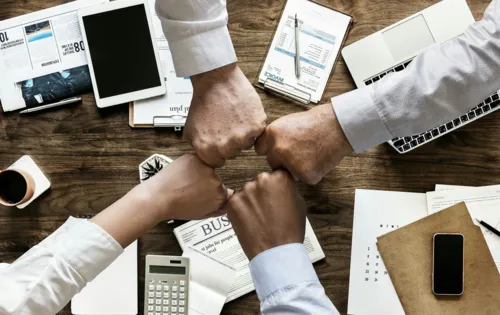 Symbolbild Teamwork: 4 F&auml;uste symbolisieren Zusammenarbeit