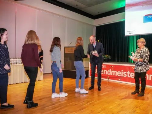 Mehrere Personen bei einer Auszeichnung. Der Oberbürgermeister schüttelt einer jungen Frau die Hand und gratuliert.