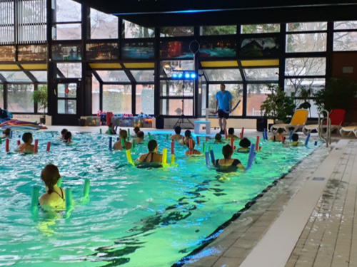 Menschen mit Poolnudeln im Wasser