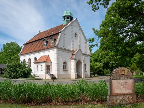 Ein Gebäude in einer grünen Friedhofsanlage.
