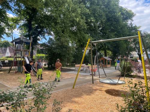 Personen auf einem Spielplatz, die letzte Arbeiten ausführen.