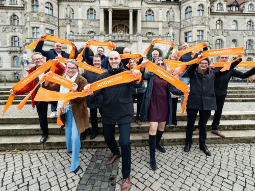 Personen stehen auf der Freitreppe vor dem Neuen Rathaus und halten Banner mit dem Schriftzug "Knowember" in den Händen.