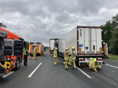 Zwei LKW , die ineinander gefahren sind und Feuerwehrleute