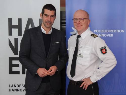 Zwei Männer vor Plakaten.