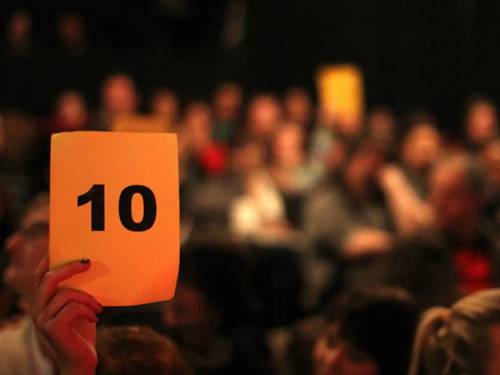 Im Publikum hält jemand einen Zettel mit der Zahl 10 hoch