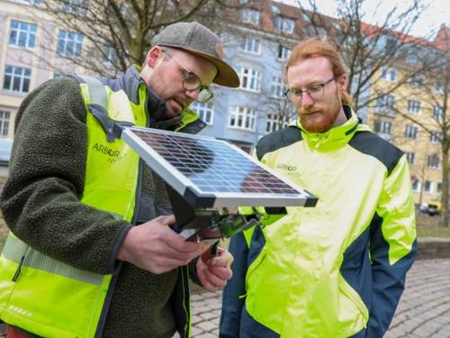 Zwei Männer mit einem Solarmodul.