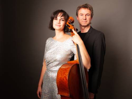 Ein Musiker und eine Musikerin, mit Cello, stehen nebeneinander in Abendkleidung