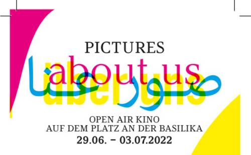 Schriftzug: Pictures about us. Das "About us" steht auch in deutscher und arabischer Übersetzung auf dem Bild. Darunter steht "Open Air Kino auf dem Platz an der Basilika. 29.06. - 03.07.2022".