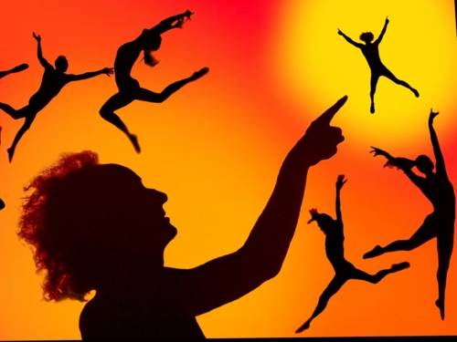 Zu sehen sind Menschen-Silhouetten in athletischen Bewegungen vor einem rot-orange-gelben Hintergrund.