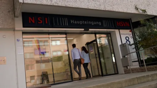 Zwei Menschen gehen auf ein Glastür zu.