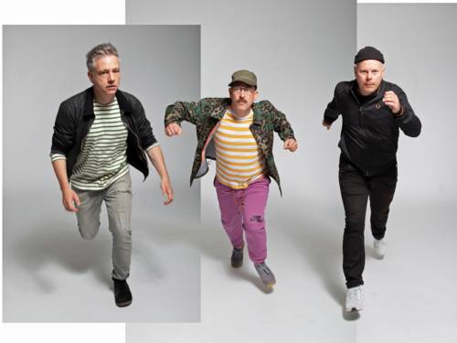 Drei Männer mittleren Alters laufen in einem Studio.