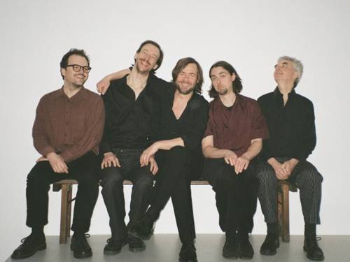 Fünf Männer sitzen auf einer Bank.