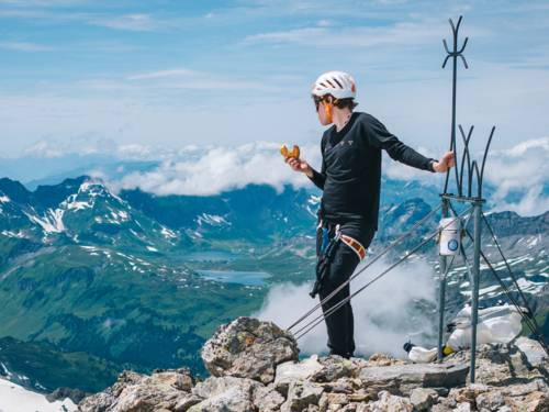 Bergsteiger an einem Gipfelkreuz