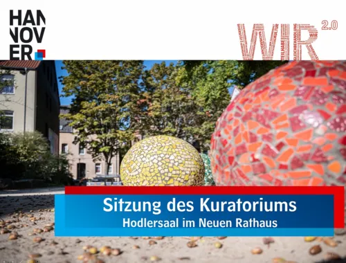 Eine Powerpoint-Begrüßungsfolie. Zu sehen sind oben links das Logo der Landeshauptstadt Hannover, oben rechts das WIR2.0-Logo und unten in einer rot-blauen Kartusche der Schriftzug "Sitzung des Kuratoriums - Hodlersaal im Neuen Rathaus". Im Hintergrund ein Bild mit zwei Steinkugeln, die mit roten und gelben Mosaiken beklebt sind.