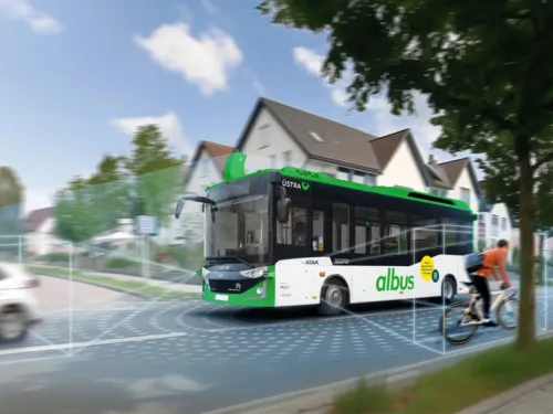 Ein Bus mit der Aufschrift "albus" fährt durch ein Wohngebiet, künstliche Linien im Bild sollen visualisieren, wie der autonome Bus seine Umgebung scannt.