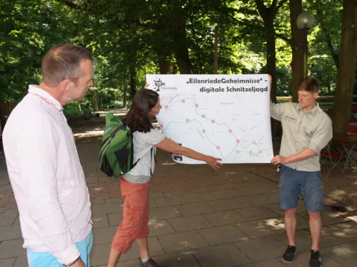 Drei Personen mit einer Karte, auf der "EilenriedeGeheimnisse" steht.
