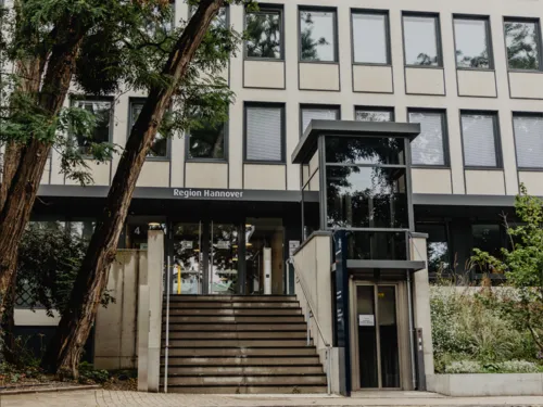 Großer Eingang zu einem Bürogebäude mit Treppe und Fahrstuhl